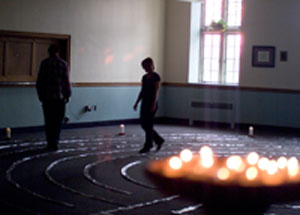 Two students standing in a quiet room with candles lit