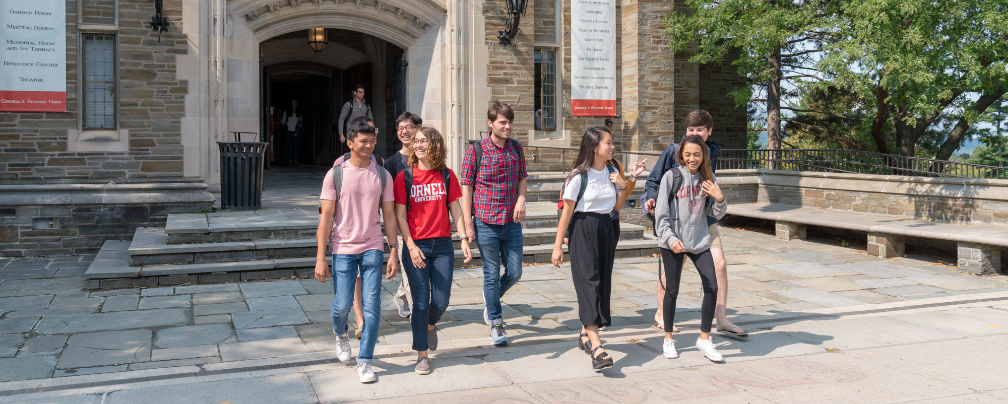 Students walking and talking outside of Willard Straight Hall on Ho Plaza