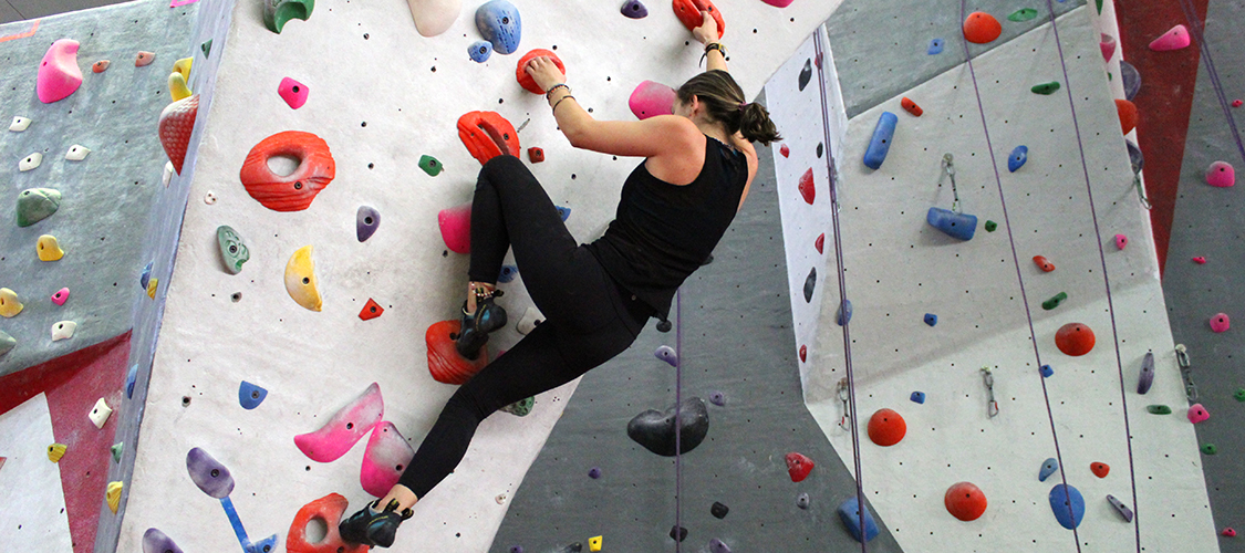 A student climbing on the bouldering wall
