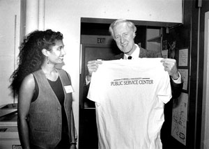 President Emeritus Frank Rhodes standing beside a student holding a Public Service Center shirt 