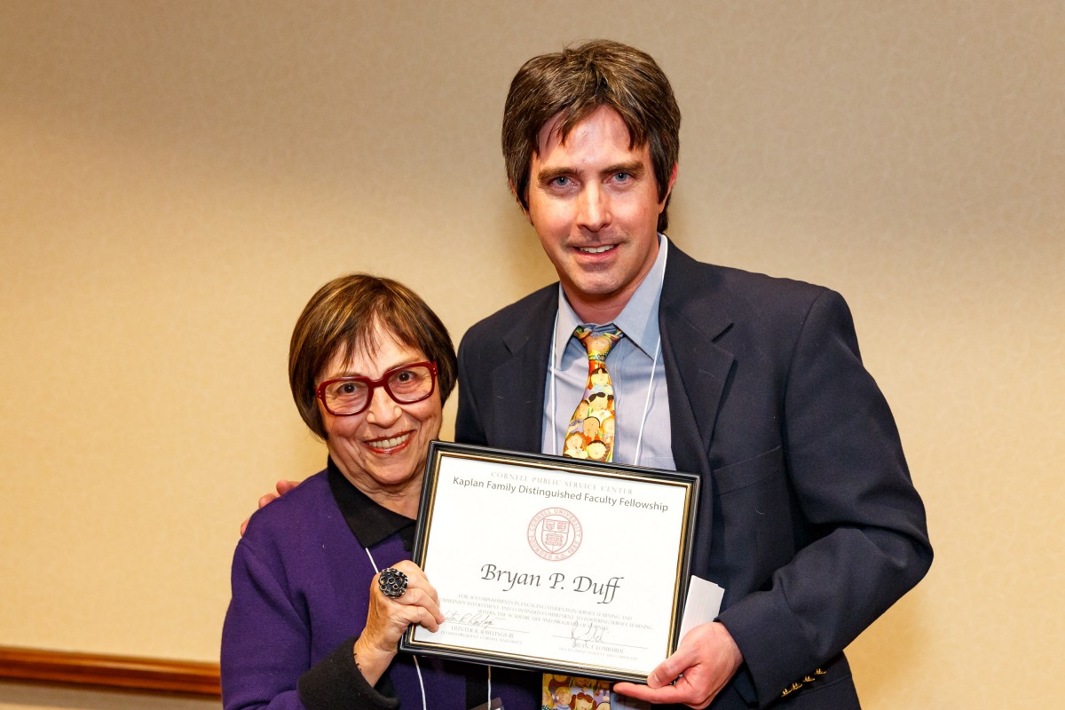 Bryan Duff standing with a woman while holding an award