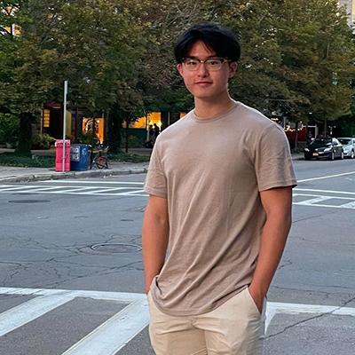 Sawyer Huang stands outside on a city street