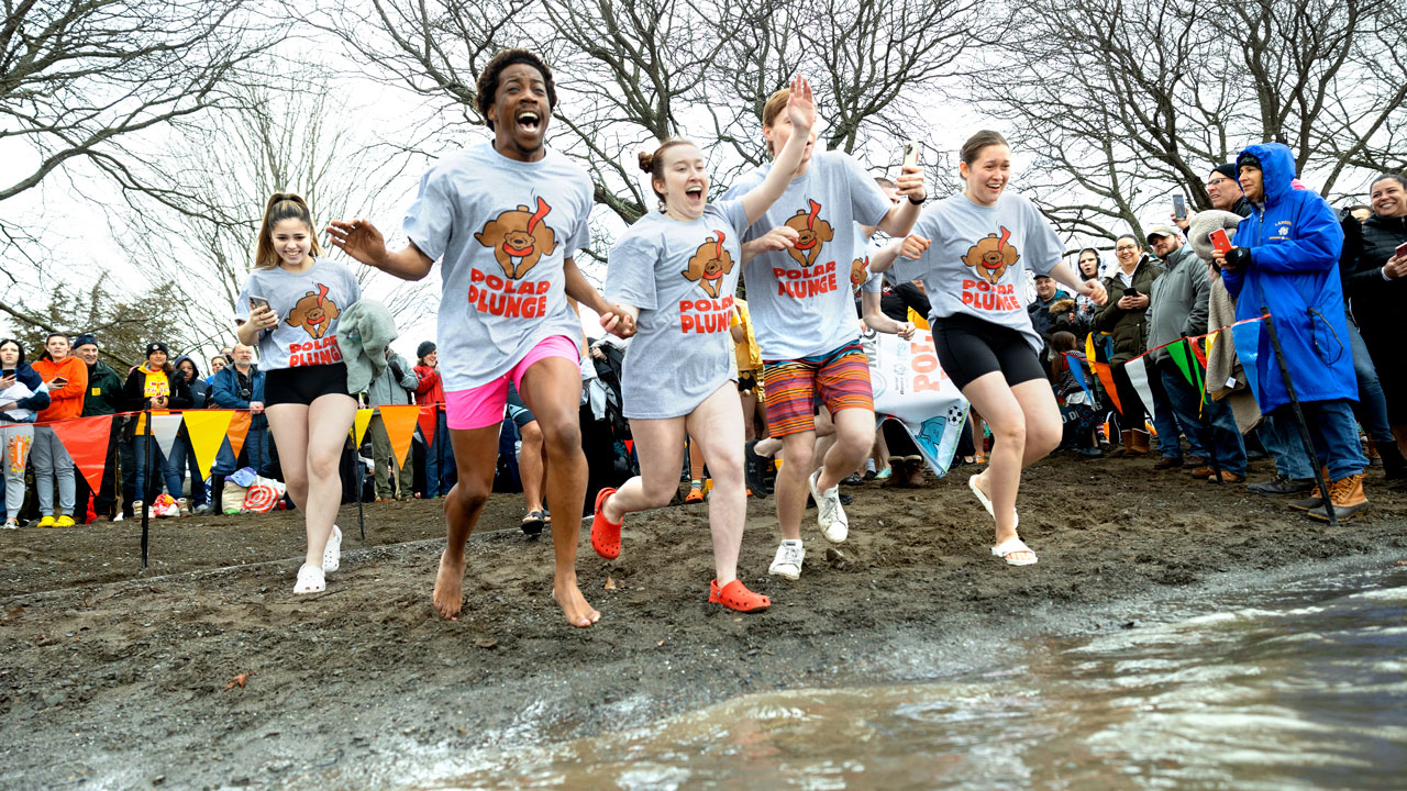 Four Cornell students run into the water