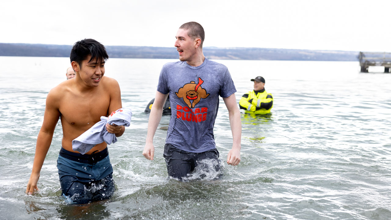 Three students stand in the cold water