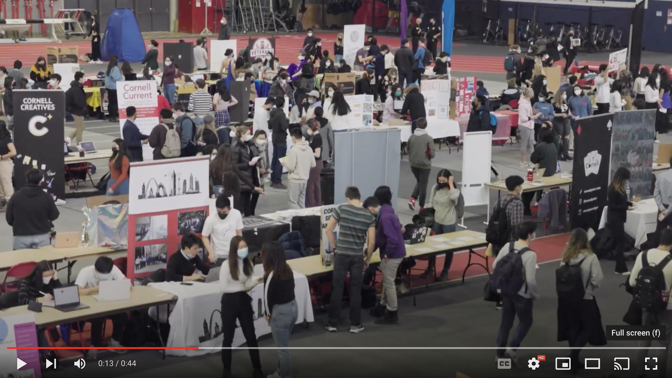 Students, tables, and booths in a large hall advertising clubs that exist at Cornell.