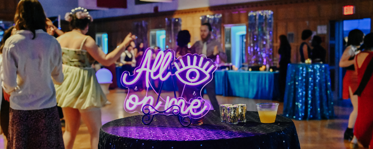 A neon sign on a table at a school dance.