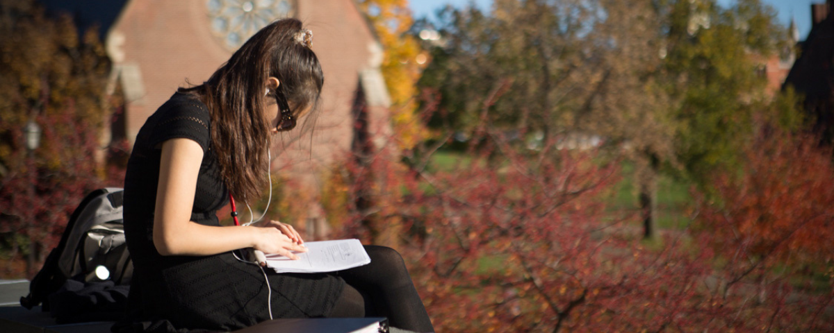 A student relaxes on the Uirs Library balcony in fall.