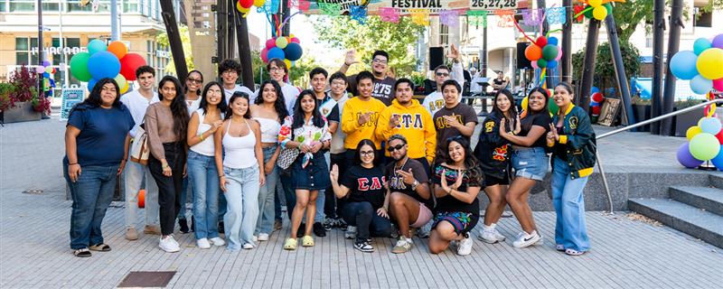 Students pose in Downtown Ithaca outdoors.
