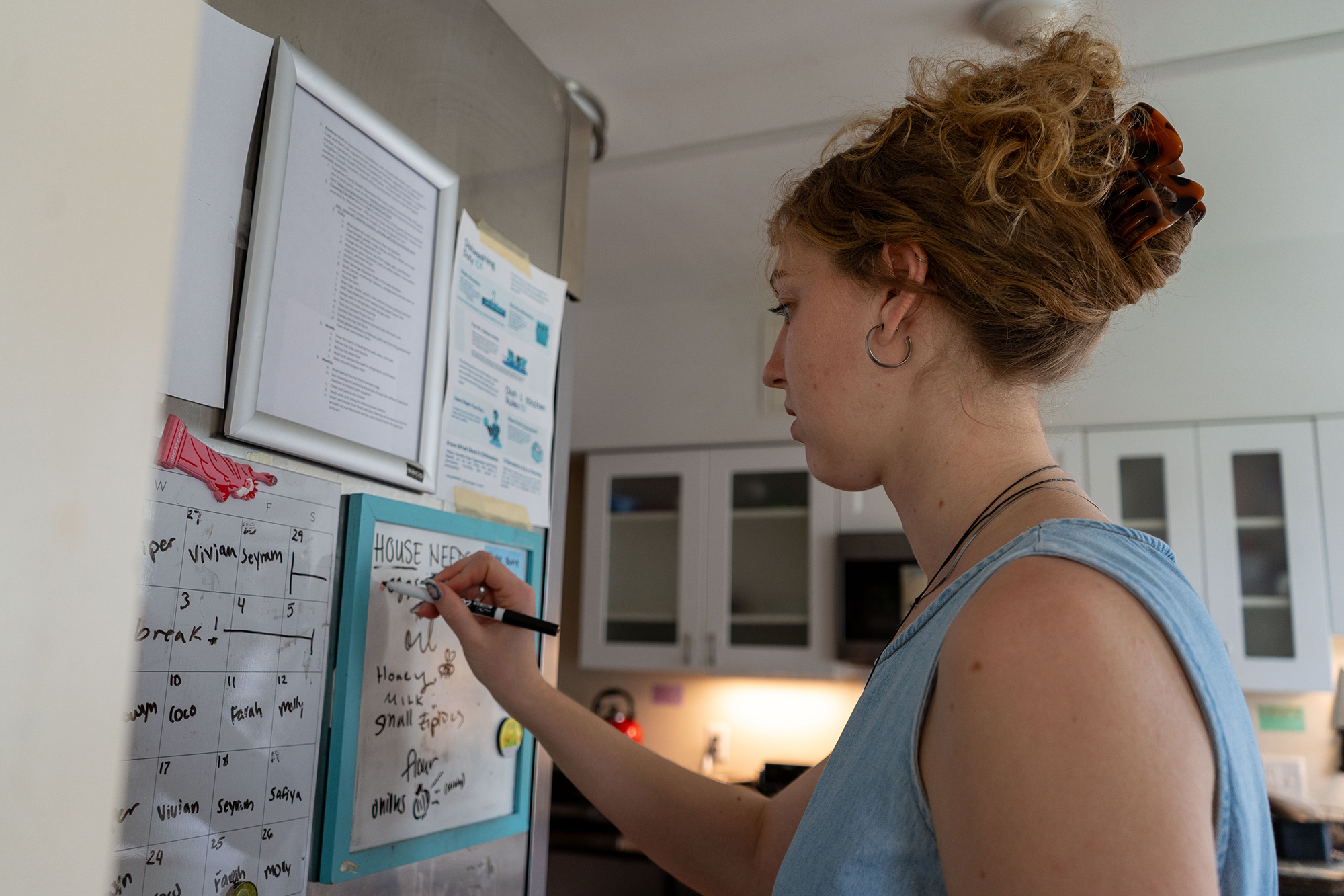 Julia Dahl '25 makes notes on the house's chore board