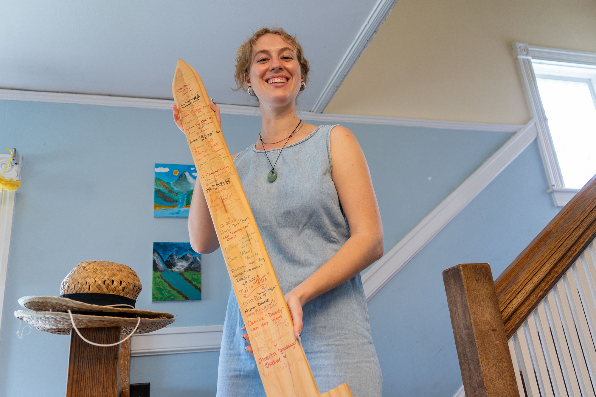 Julia holds a wooden sword that Wait Ave seniors sign upon leaving the co-op