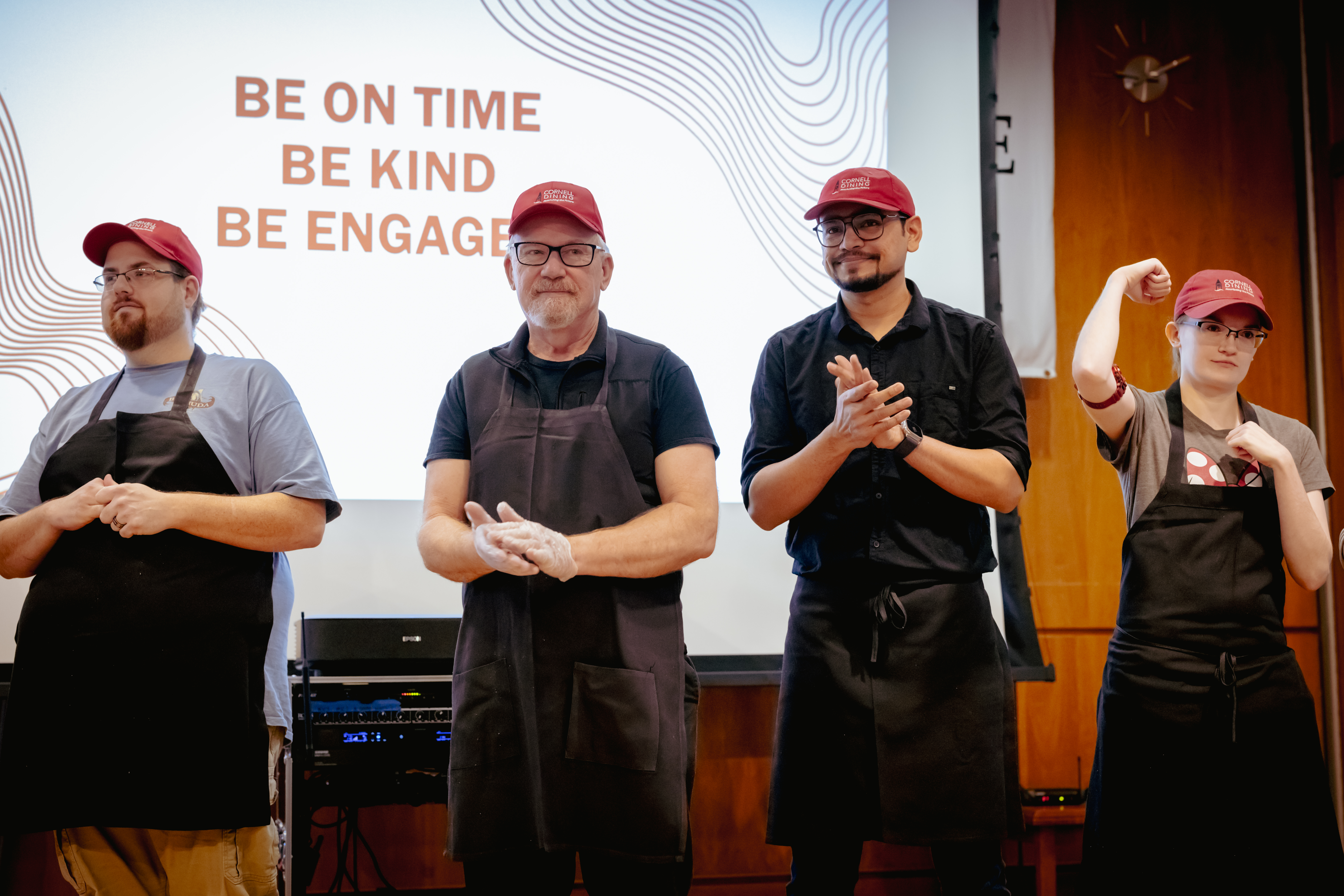 Cornell dining team members on stage at a training event
