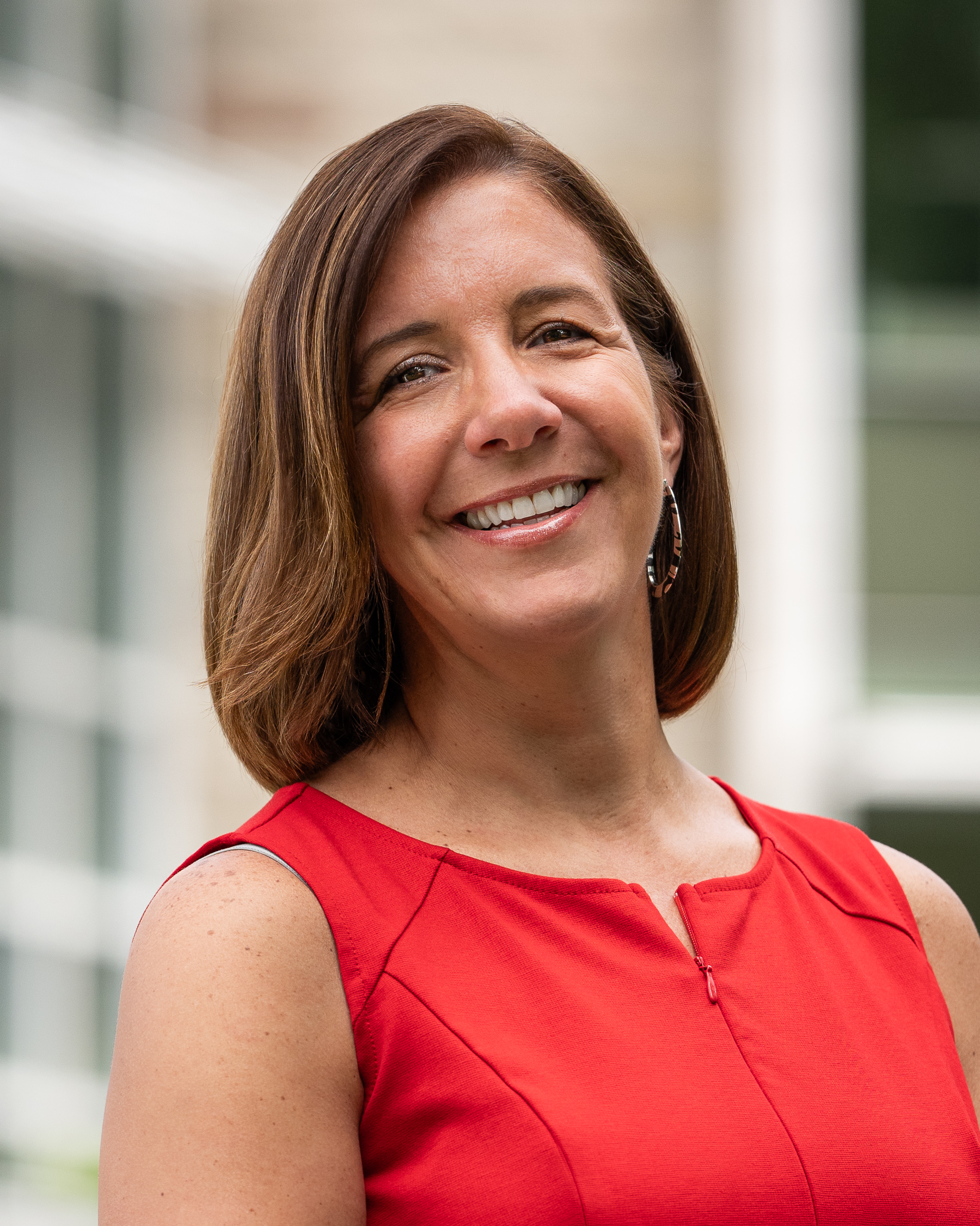 photo of a woman with shoulder length brown hair wearing a red dress