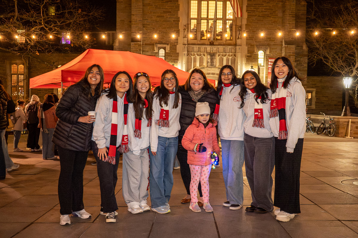 Students and staff pose in front of lights on Ho Plaza