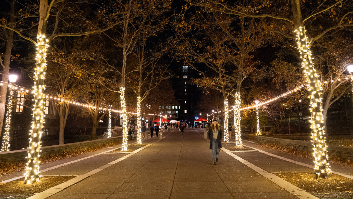 Student walking on a brightly light Ho Plaza