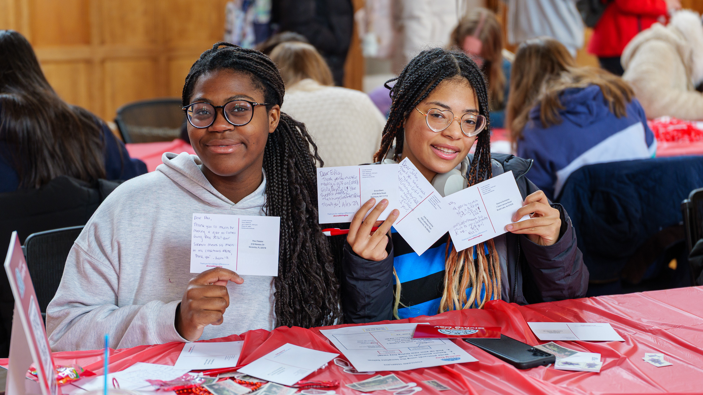 two students holding up thank you cards