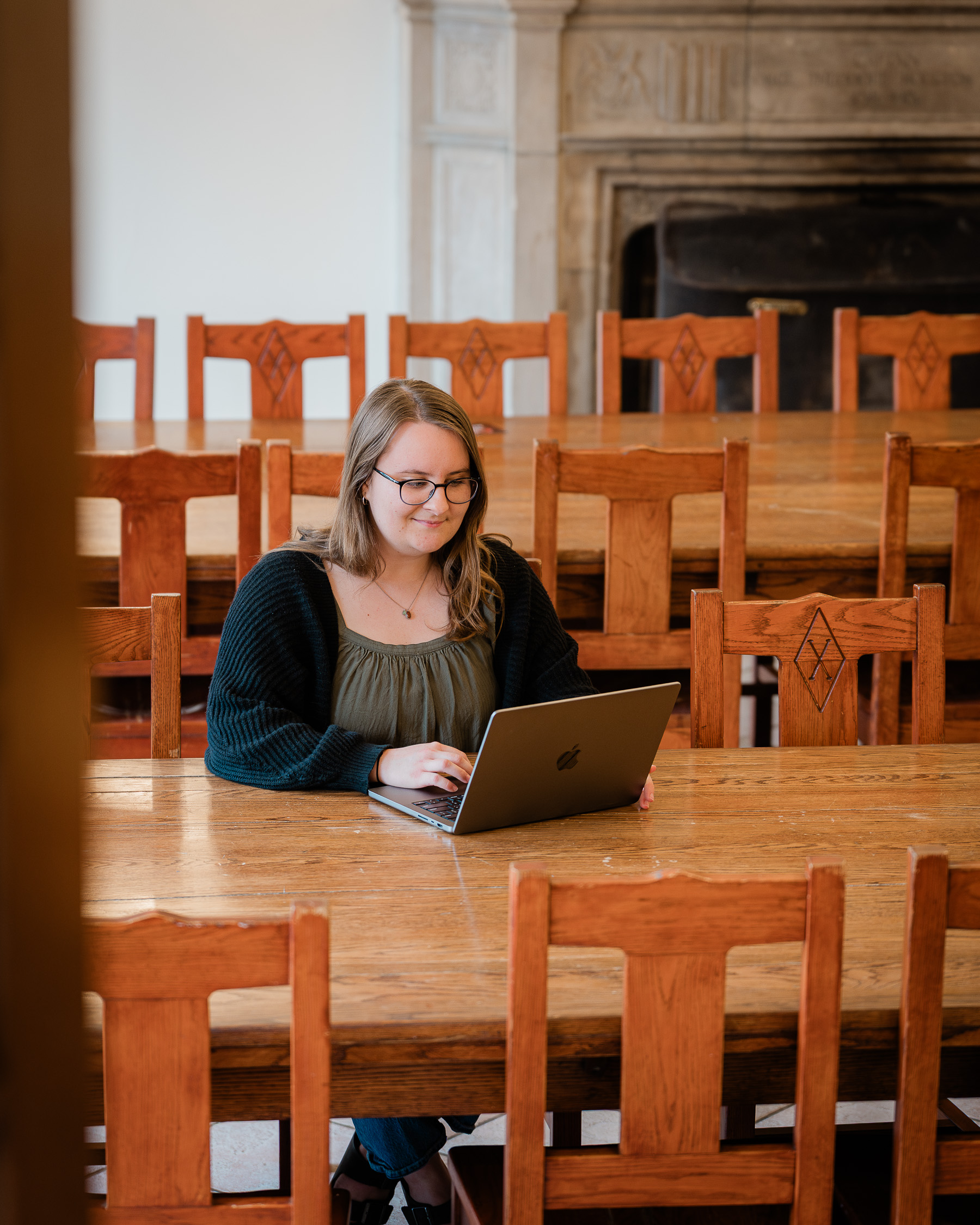 Student sits with a laptop at a table to study at EEC