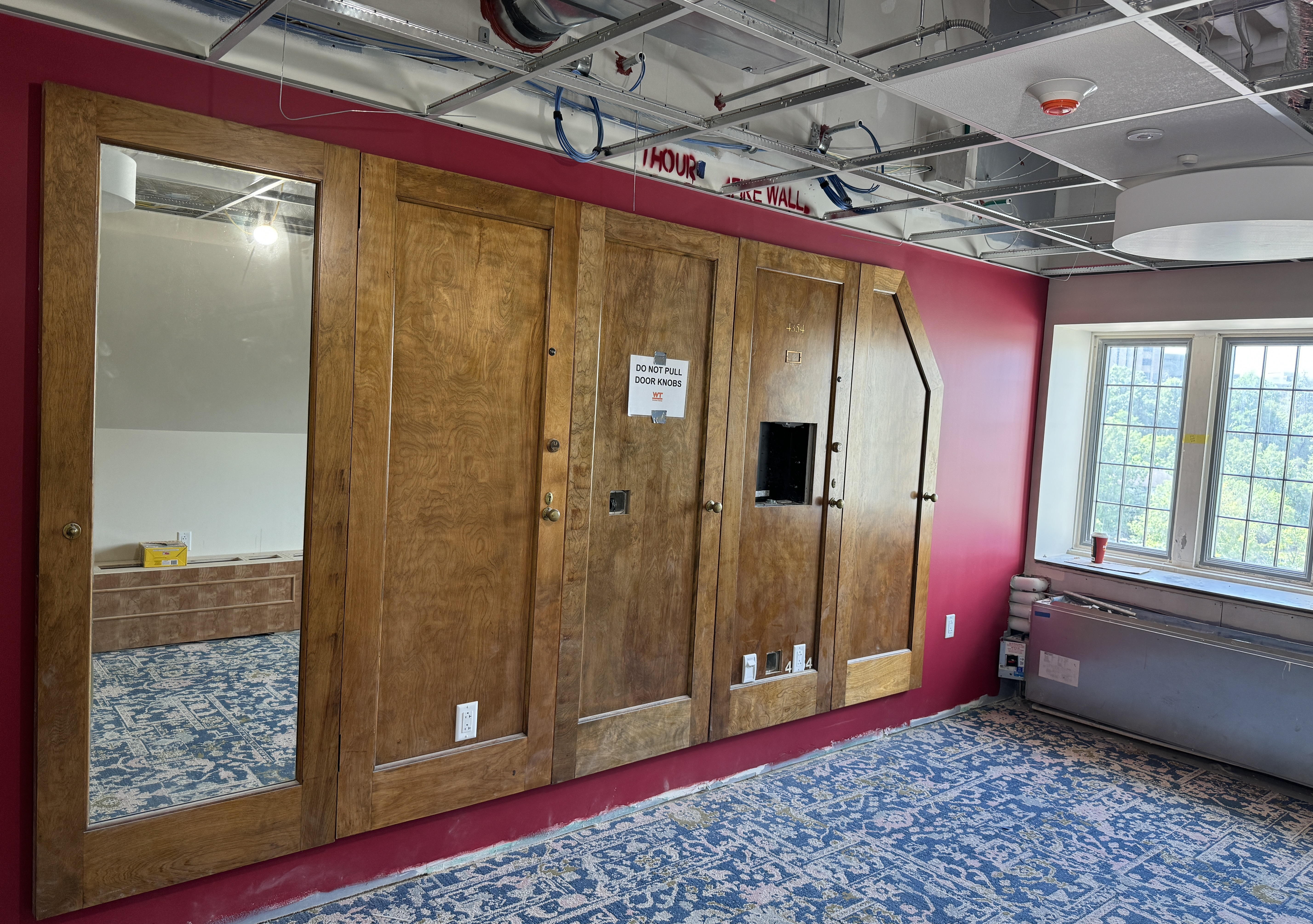 Old wood door panels amid new construction in a common room