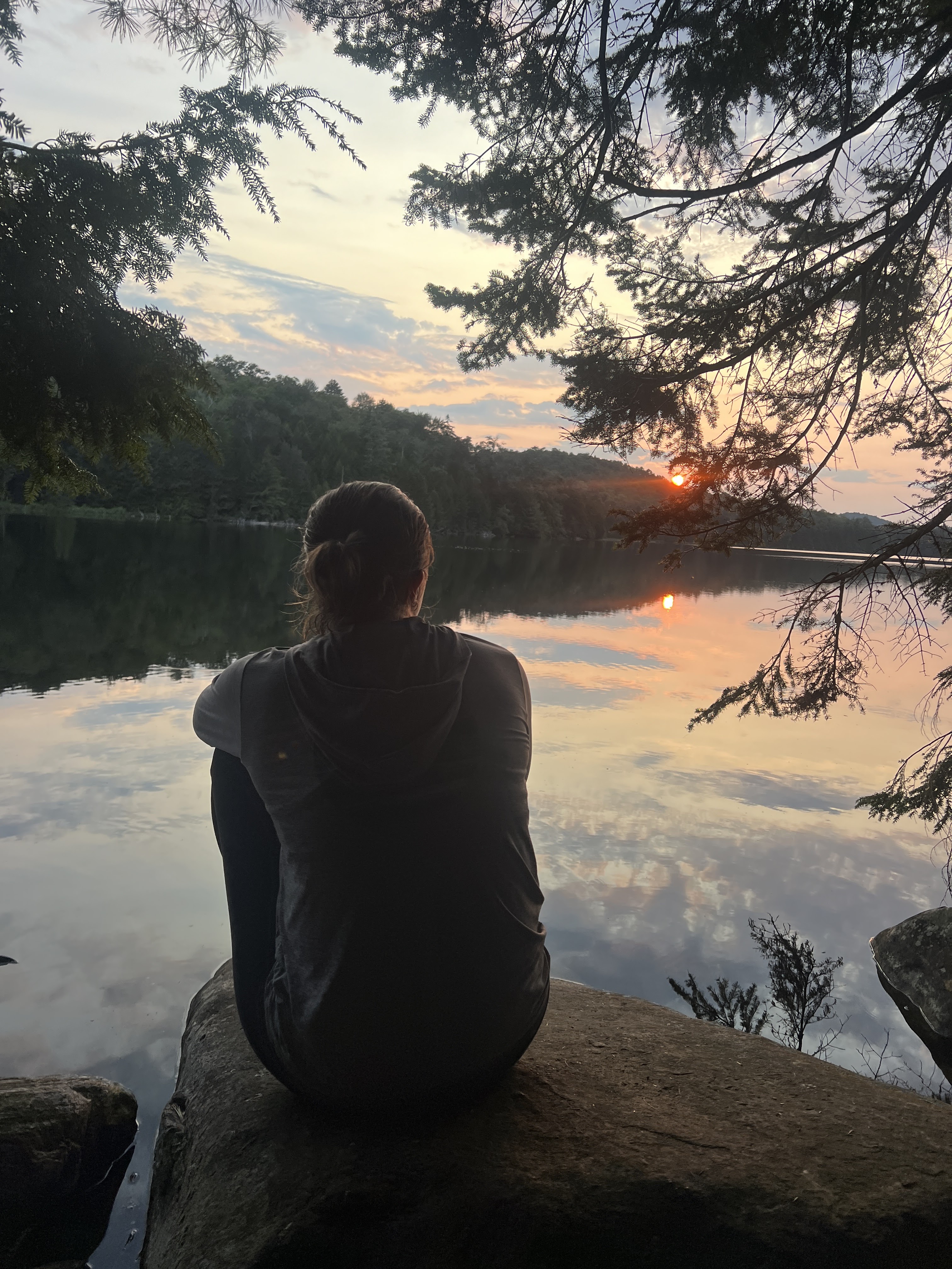 Odyssey trip participant watches a sunset over a lake in the Adirondacks.