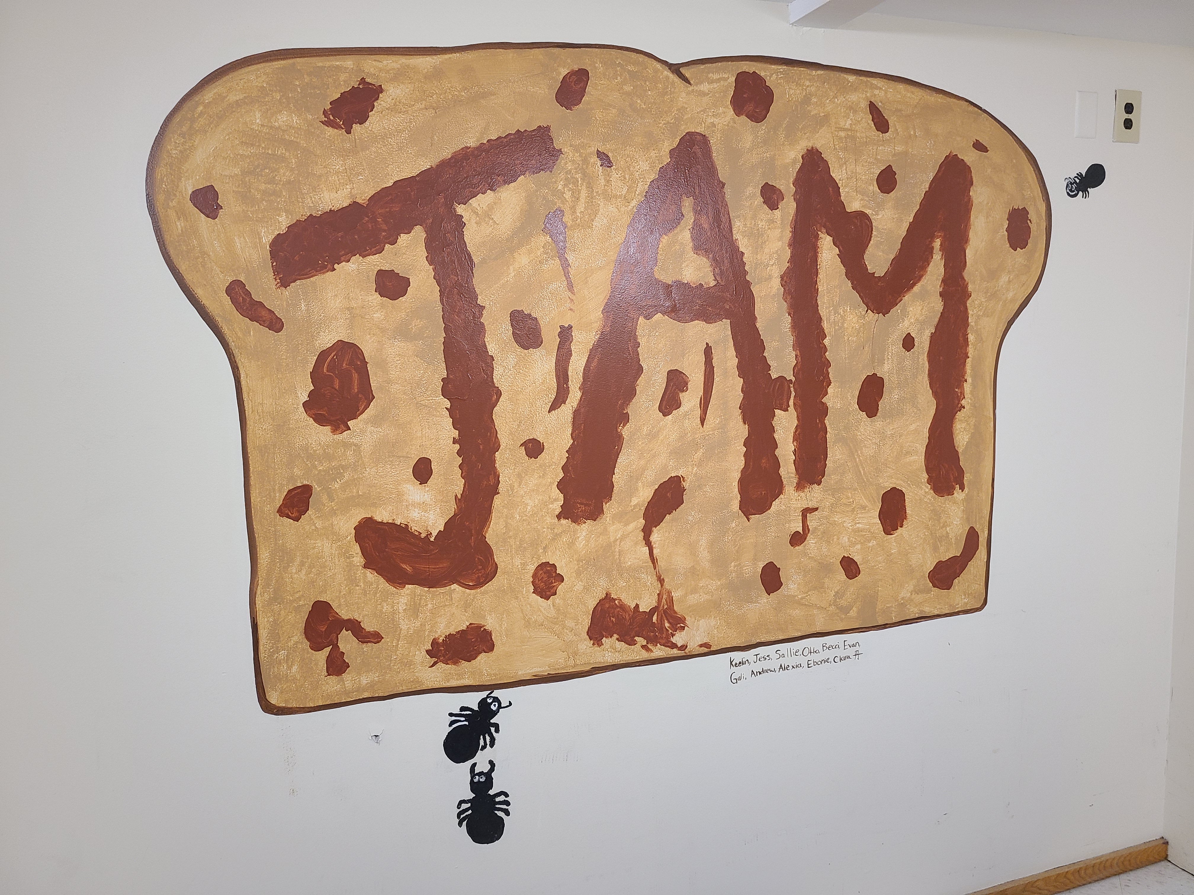 Photo of a piece of toast painted on a wall with "JAM" written on it
