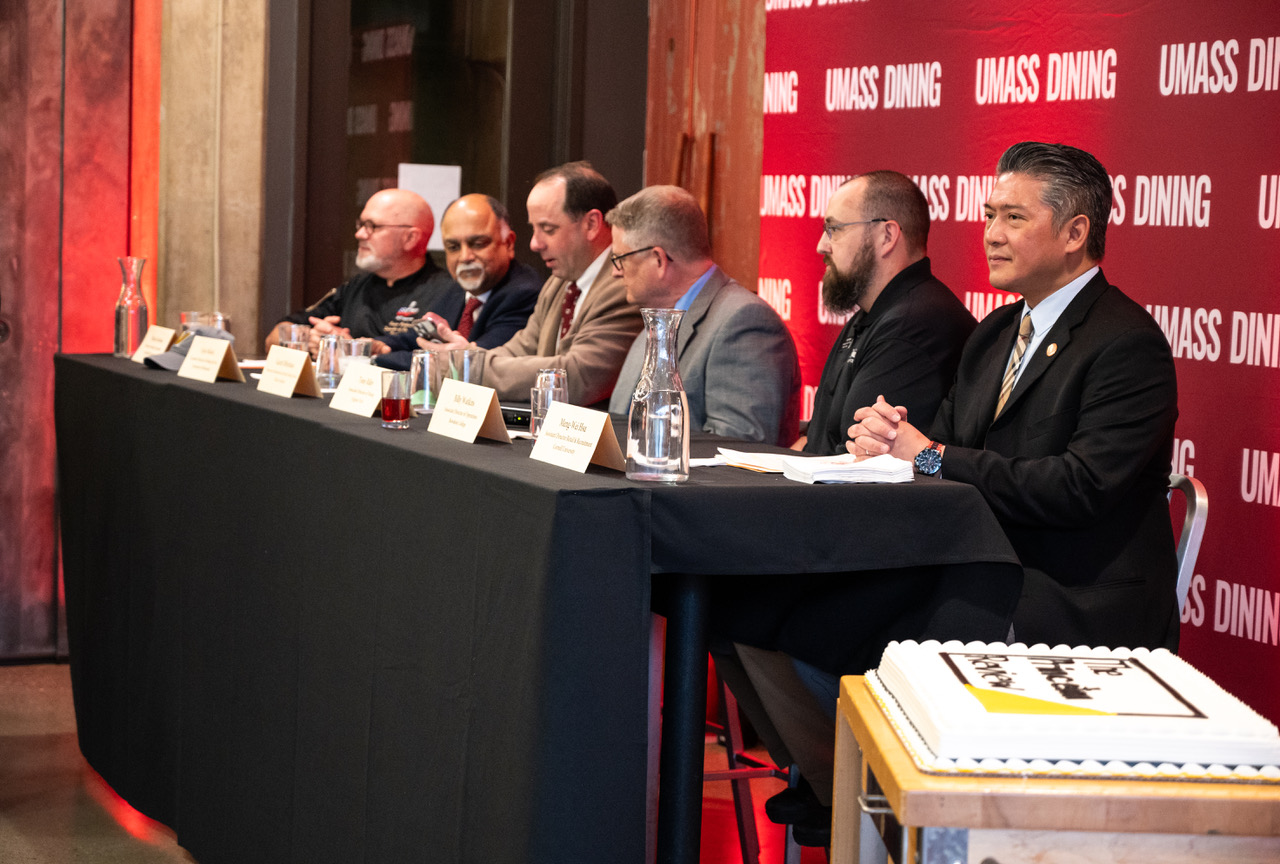 A row of people at a table on a stage