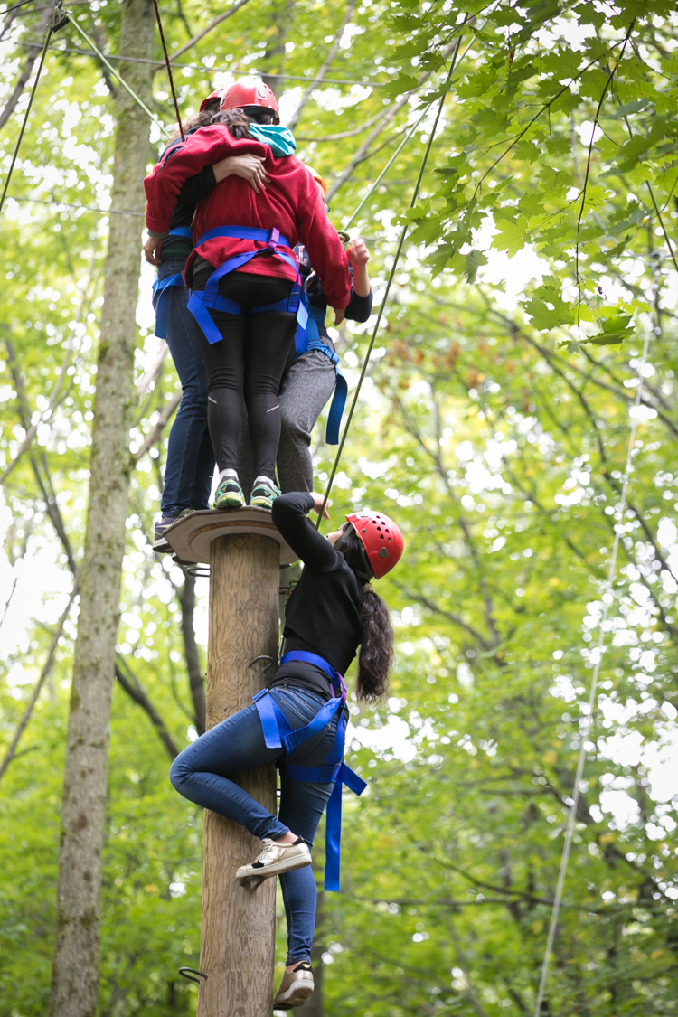 Participants climbing up the quadraphenia element on the Hoffman Challenge Course