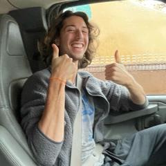 Photo of Blue Shapiro giving thumbs up on a trip with Cornell Outdoor Education sitting in a van