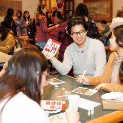 Person sitting at a table in willard straight hall holding up a brochure