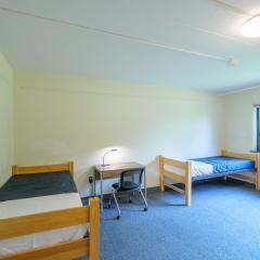 A bedroom with two twin beds, tables, and chairs.