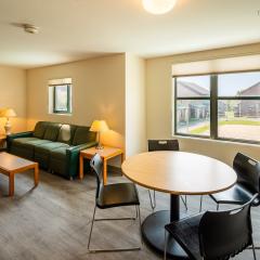 living room with a couch, two side tables, a coffee table, lamps and a dining table and chairs.