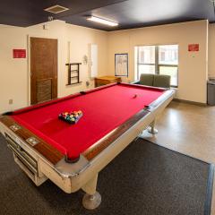 Lounge area of the laundry room with a pool table, couch, and table.
