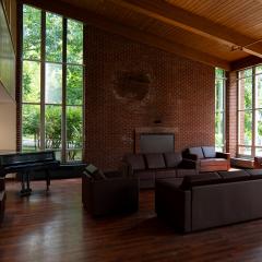 104 Mary Anne Wood Drive main lounge with couches, chairs, tables, a fire place, and a grand piano.