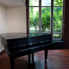 A grand piano in front of windows