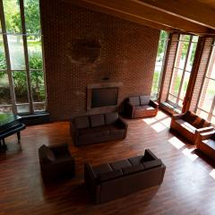104 Mary Anne Wood Drive main lounge with couches, chairs, tables, a fire place, and a grand piano.