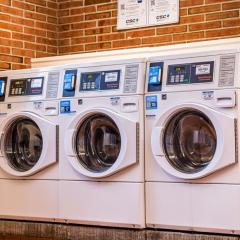Three front-loading washing machines in High Rise 5's laundry room