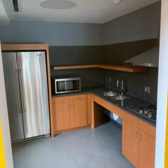 A kitchen in Hu Shih Hall featuring a refrigerator, microwave, cabinets, and a kitchen sink