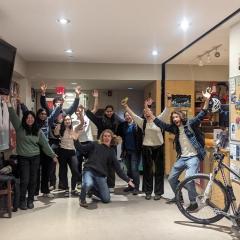 group of students looking excited with bike leaning against a workbench