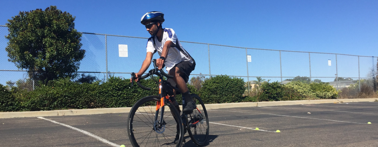 Man riding bike in parking lot practicing weaving maneuvers