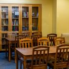 library with wooden tables and chairs as well as bookcases with books