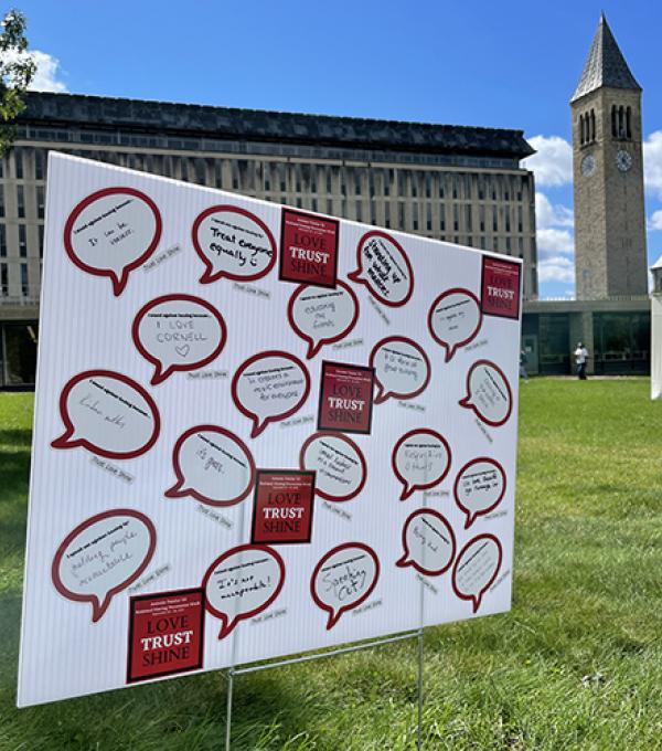 Poster board with hazing prevention messages written on it placed in front of McGraw Tower