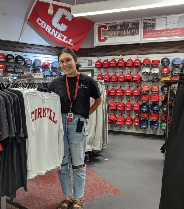 Ella Hsu '25 stands amidst inventory at the Cornell Store where she works.