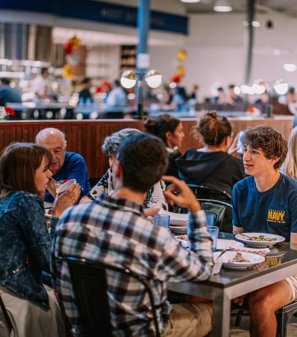 A table of diners inside a campus dining room