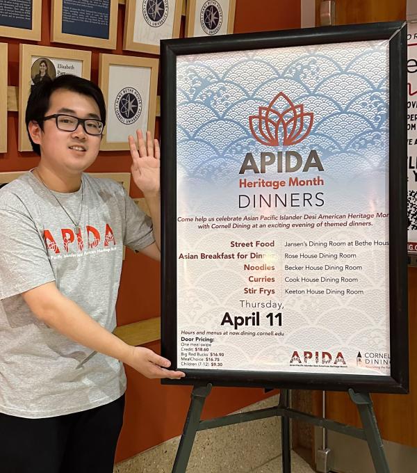 Jason Xiong '25 in front of an APIDA Heritage Month promotional sign.