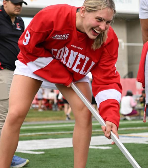 Cornell women’s hockey player Lindzi Avar plays box hockey with a young girl at Cornell Community Field Day