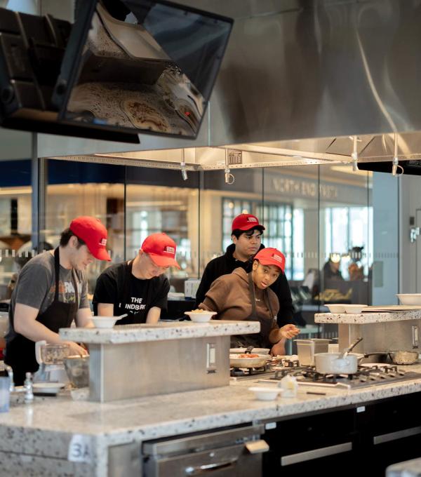 Students cook in a shared teaching kitchen