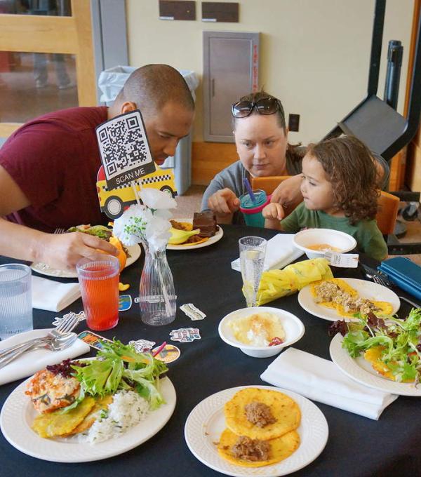 Adults and a child around a table with plates of food