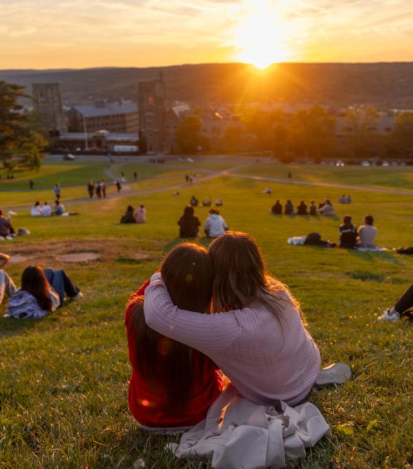 Students watch sunset on Libe Slope