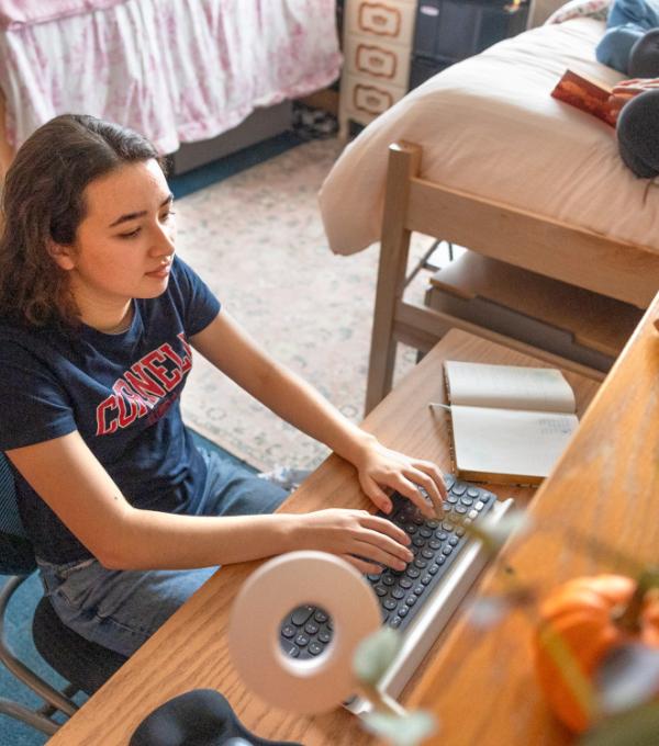 Female student working at desk in residence hall.