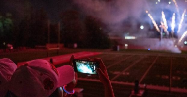 Student recording fireworks show on their phone.