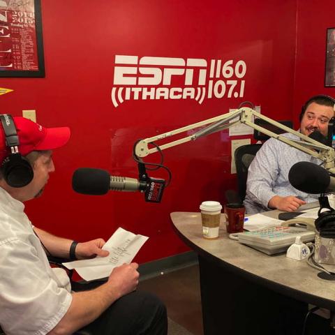 Two people at microphones in a radio studio