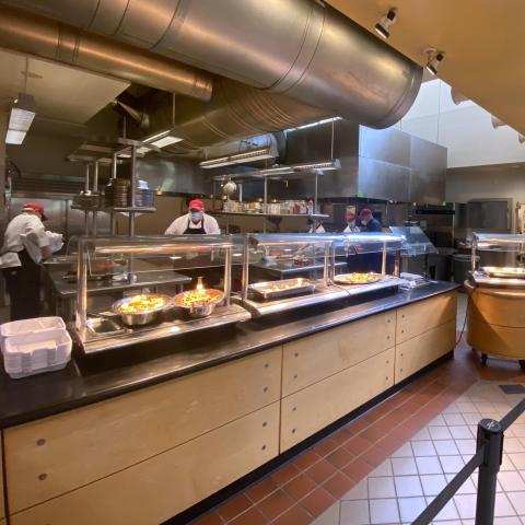 Dining staff wearing masks behind a serving line